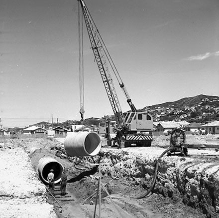 f. Workmen are using a crane to manouver drainage pipes into place