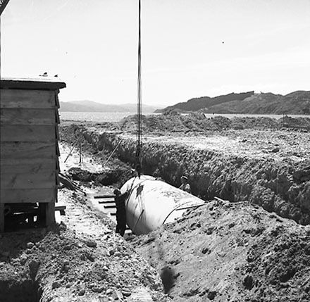 h. Workmen are using a crane to manouver drainage pipes into place