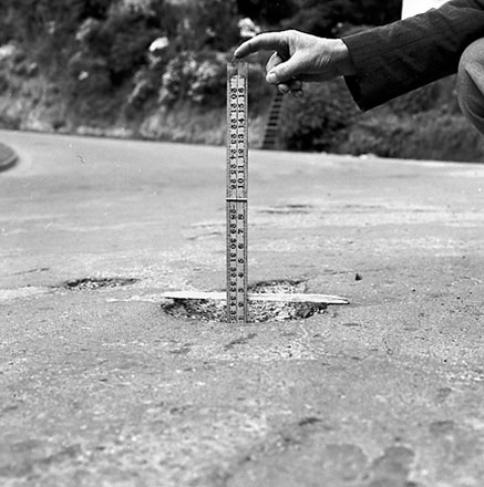 e. Workman pointing out damage to road surface