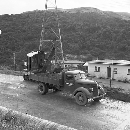 c. Views of workmen using a crane to install a new drainage pipe into trench