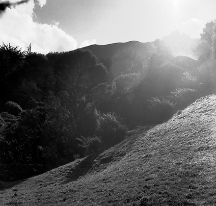 a. Intersection with Travers Street. Road works are in progress and a front end digger is being used to dig a trench. Workmen and machinery, drainage pipes are ready to be laid