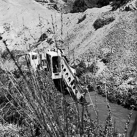 b. Gradall, large machine with scoop on front, clearing a trench