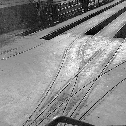 b. Interior of Tram Barns, parked tramcars, motor vehicles, tramlines