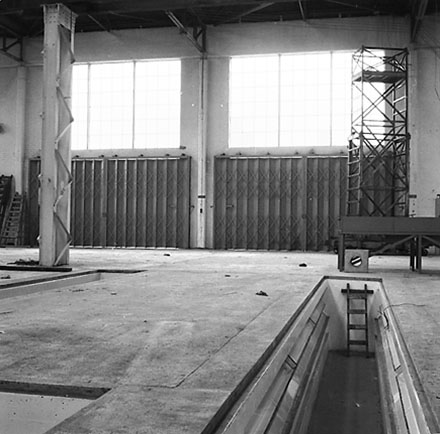 c. Interior of Tram Barns, parked tramcars, motor vehicles, tramlines