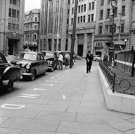 a. The Commercial Bank of Australia, Prudential Building in the background. Motor vehicles parked at taxi stand. Man in traffic uniform