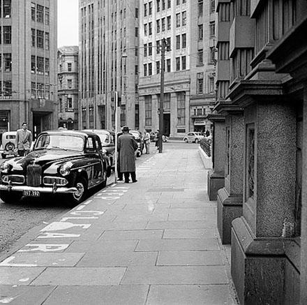 b. The Commercial Bank of Australia, Prudential Building in the background. Motor vehicles parked at taxi stand. Man in traffic uniform