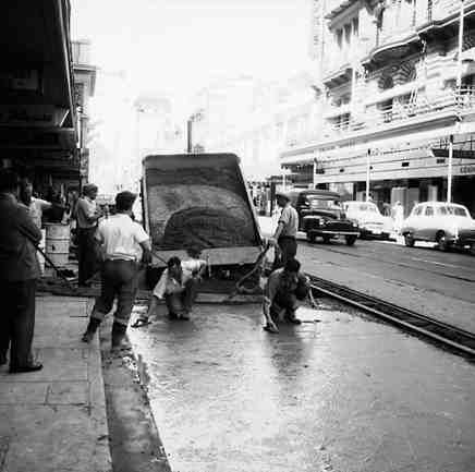 b. Workmen paving the road between the tram lines and the footpath