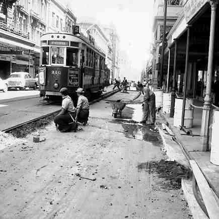 c. Workmen paving the road between the tram lines and the footpath
