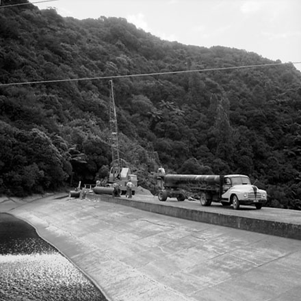 b. Workmen unloading pipes from the back of a truck