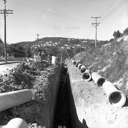b. Drainage pipes being laid in trenches