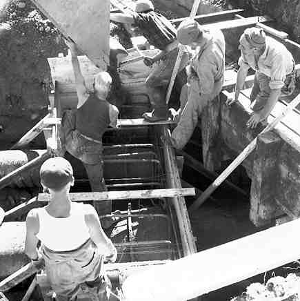 c. Karori Reservoir area, workmen installing pipes