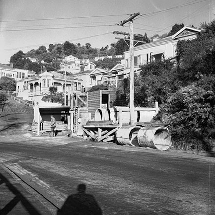 b. Possible repairs to drains in progress. Wellington City Council worksheds, workmen, residential area