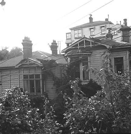 a. Views of wooden dwellings, pathways, bank covered in scub