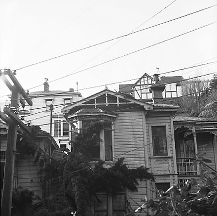 b. Views of wooden dwellings, pathways, bank covered in scub