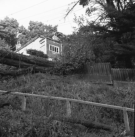 c. Views of wooden dwellings, pathways, bank covered in scub