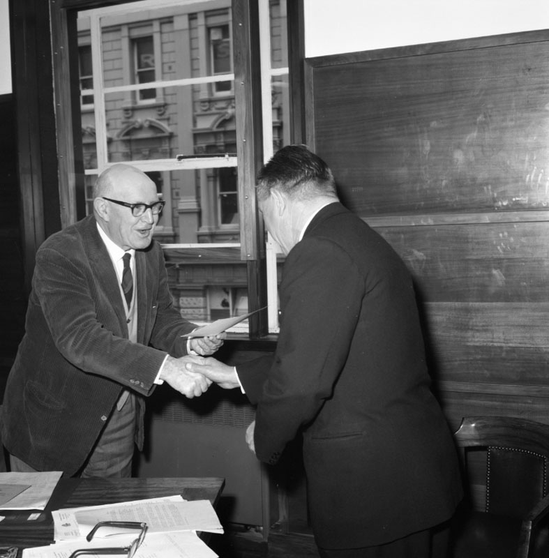 b. Mr AMF Wallis, Civil Defence Instructor, receiving instruction certificate