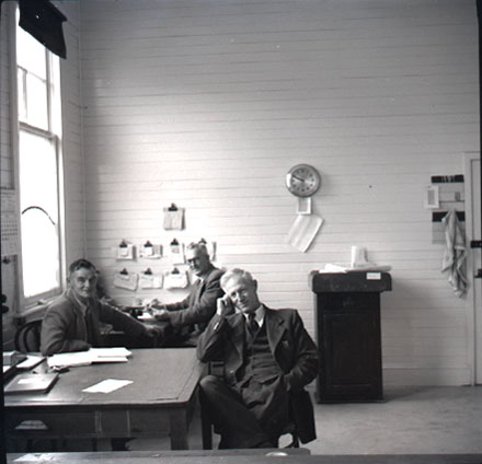 b. Three men sitting at desks in an office