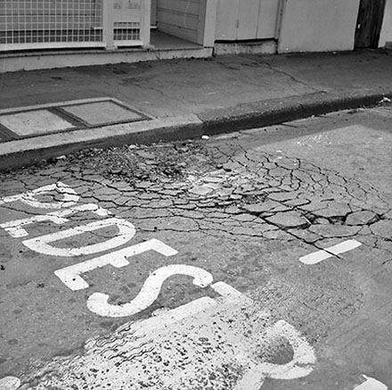 b. Damage to road surface, bus stop, Moxham Avenue