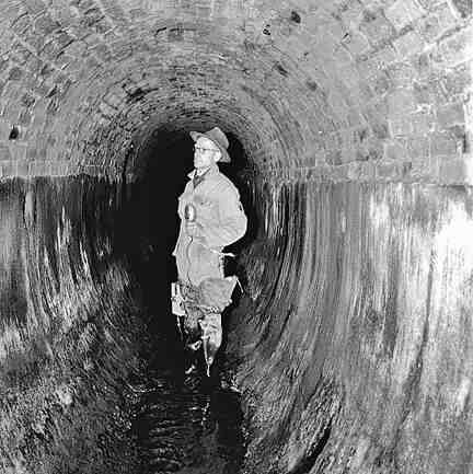 f. Workmen inspecting inside of drains