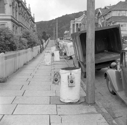 a. Footpath, motor vehicles, tramcars, white drums and lights marking area of proposed street works
