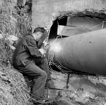 d. Workman welding pipes