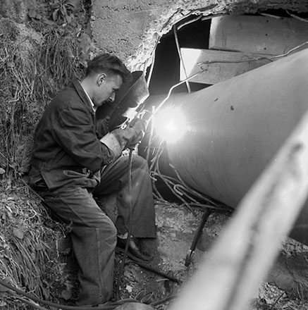 f. Workman welding pipes