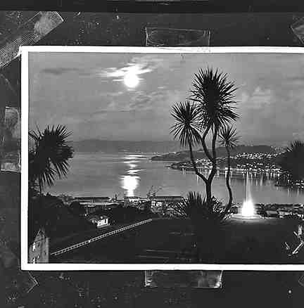 a. Copy photograph, Kelburn Park Fountain, illuminated at night Wellington Harbour in background