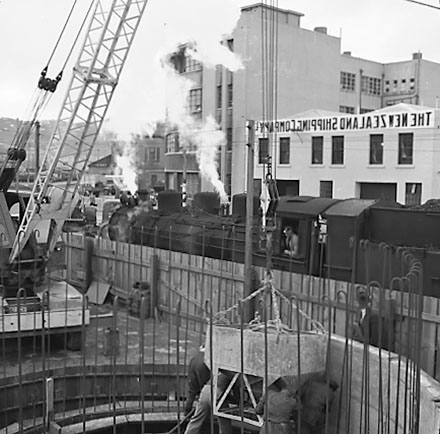 b. Workmen using overhead crane to pour concrete