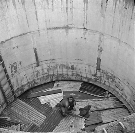 d. Views of construction, workmen using overhead crane to pour concrete