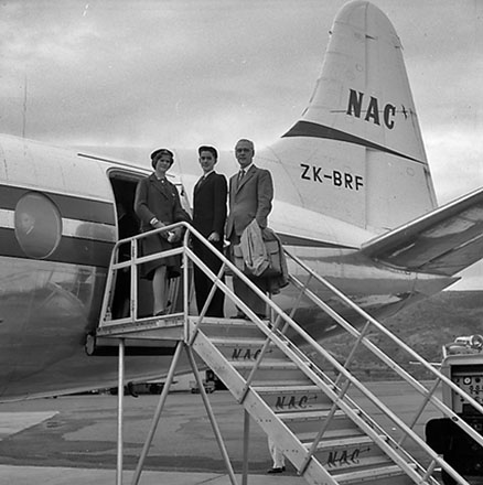 e. Group of people standing in front of an aeroplane, includes Mayor Frank Kitts, Traffic Department Supervisor Anderson and Deputy Boyden