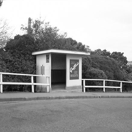 a. Unidentified location, wooden bus stop shelter, advertising for Griffins Biscuits