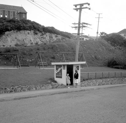 b. Unidentified location, wooden bus stop shelter, advertising for Griffins Biscuits
