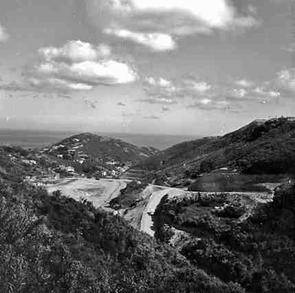 a. Elevated view of area being filled in by landfill and refuse. Pencarrow Head in the background