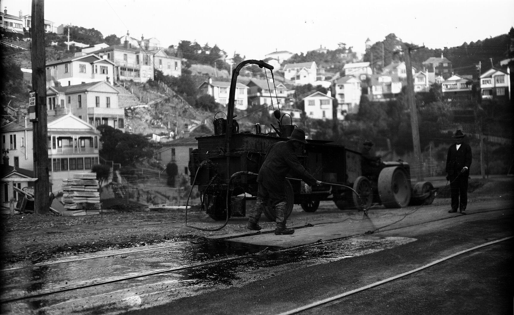 Glenmore Street, workman operating the Cold Fix Spraying Outfit and Track Roller on newly laid tram rails