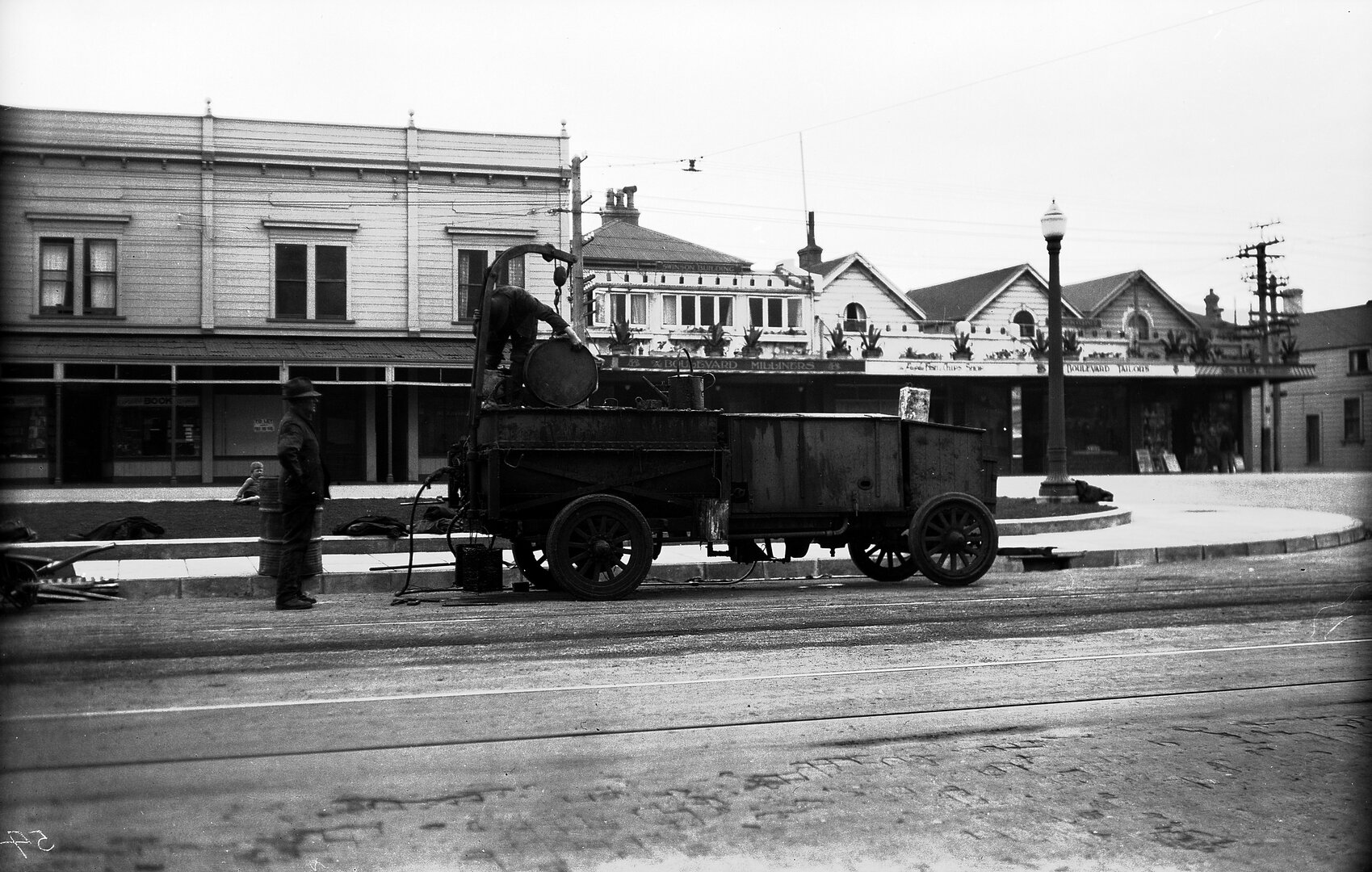 Kent Terrace, workmen hoisting drums of Cold Fix onto Cold Fix Spraying Trailer