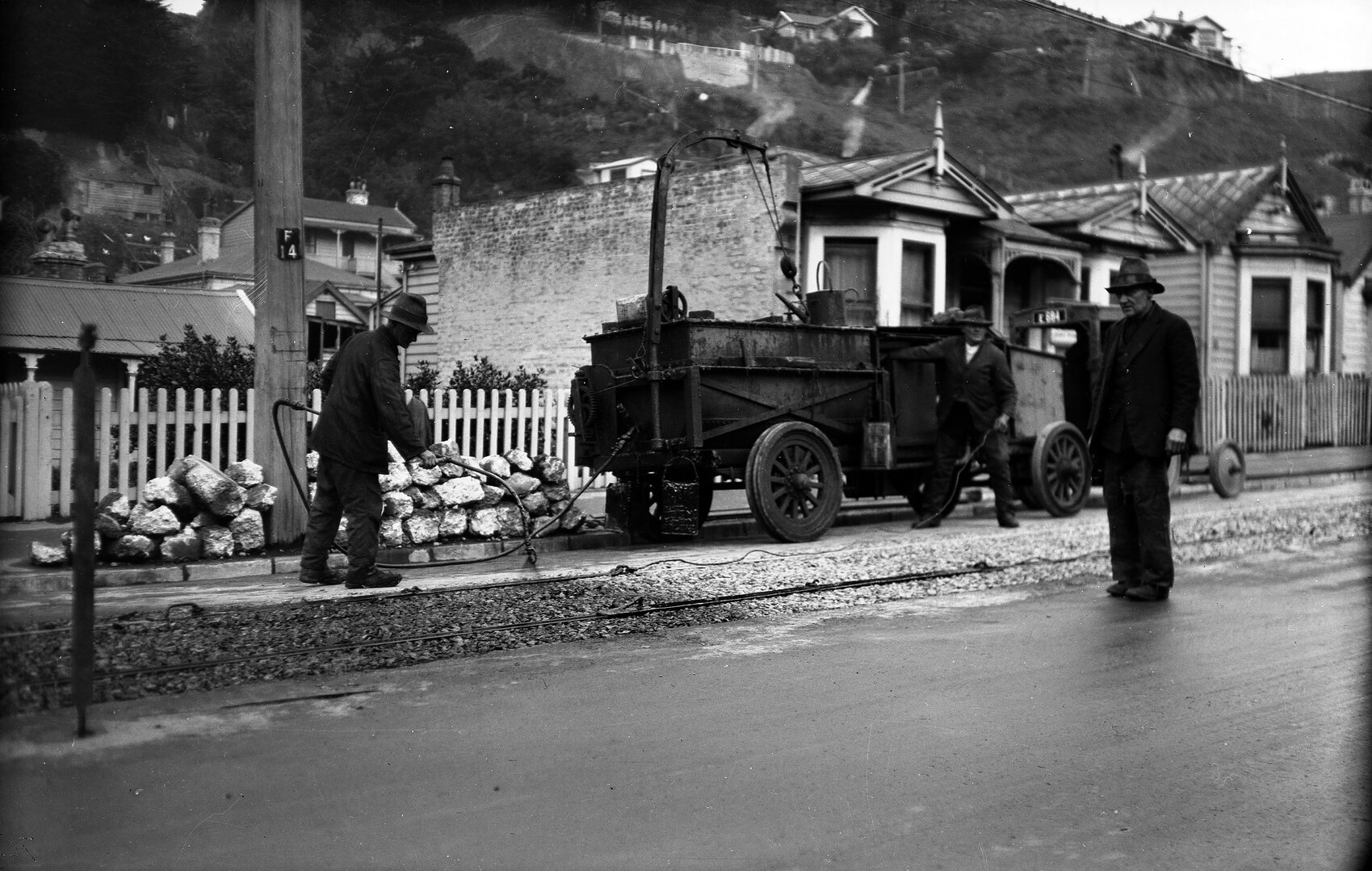 Aro Street, workmen spraying cold fix on newly laid tram rails