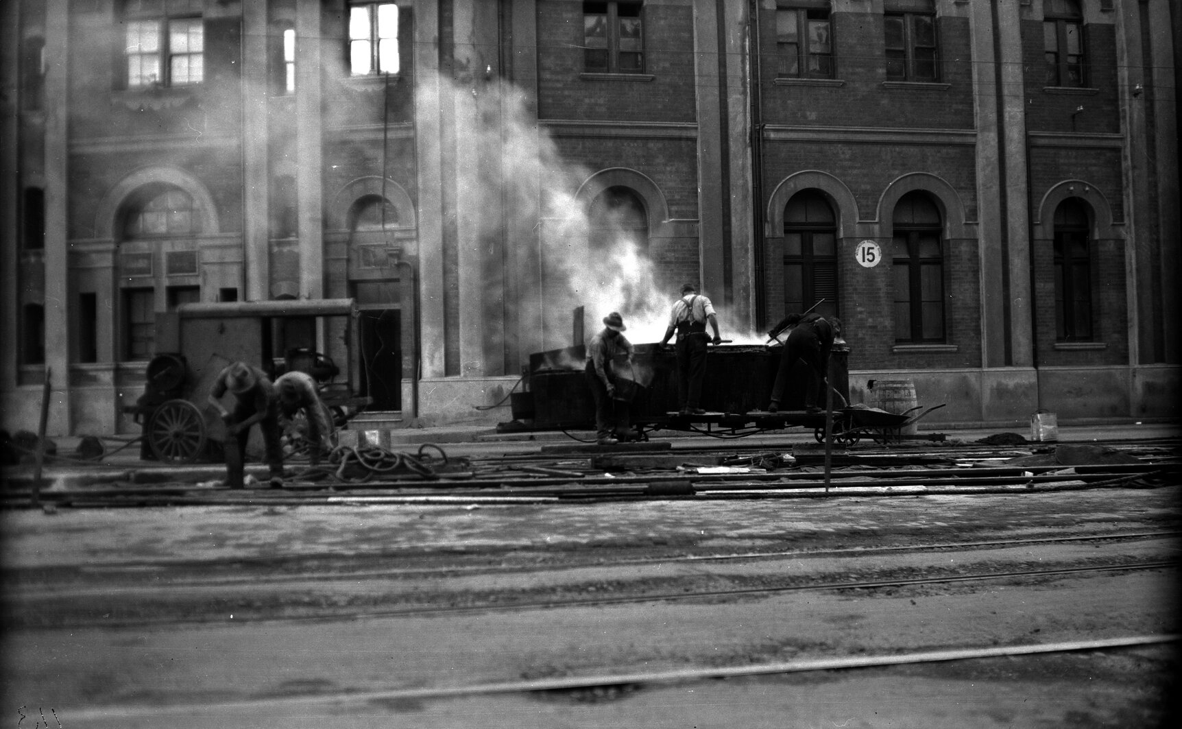 Customhouse Quay, workmen pouring tar on newly laid tram tracks
