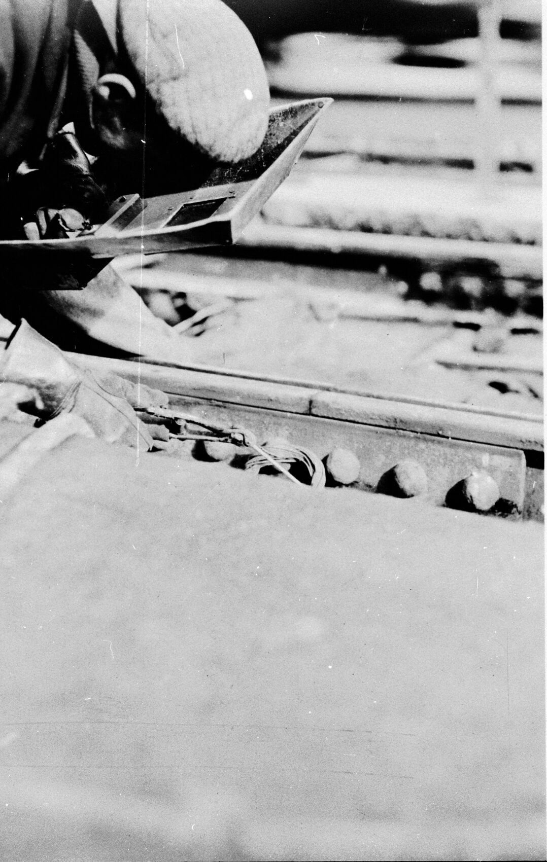 Workman welding a rail bond onto fishplate on tram track