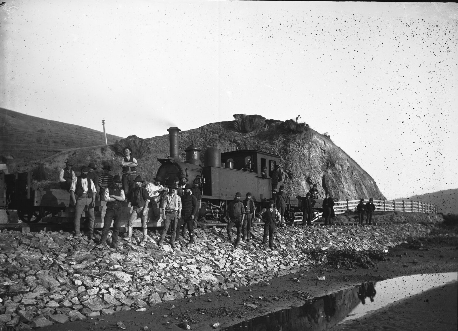 Group of men standing in front of train engine