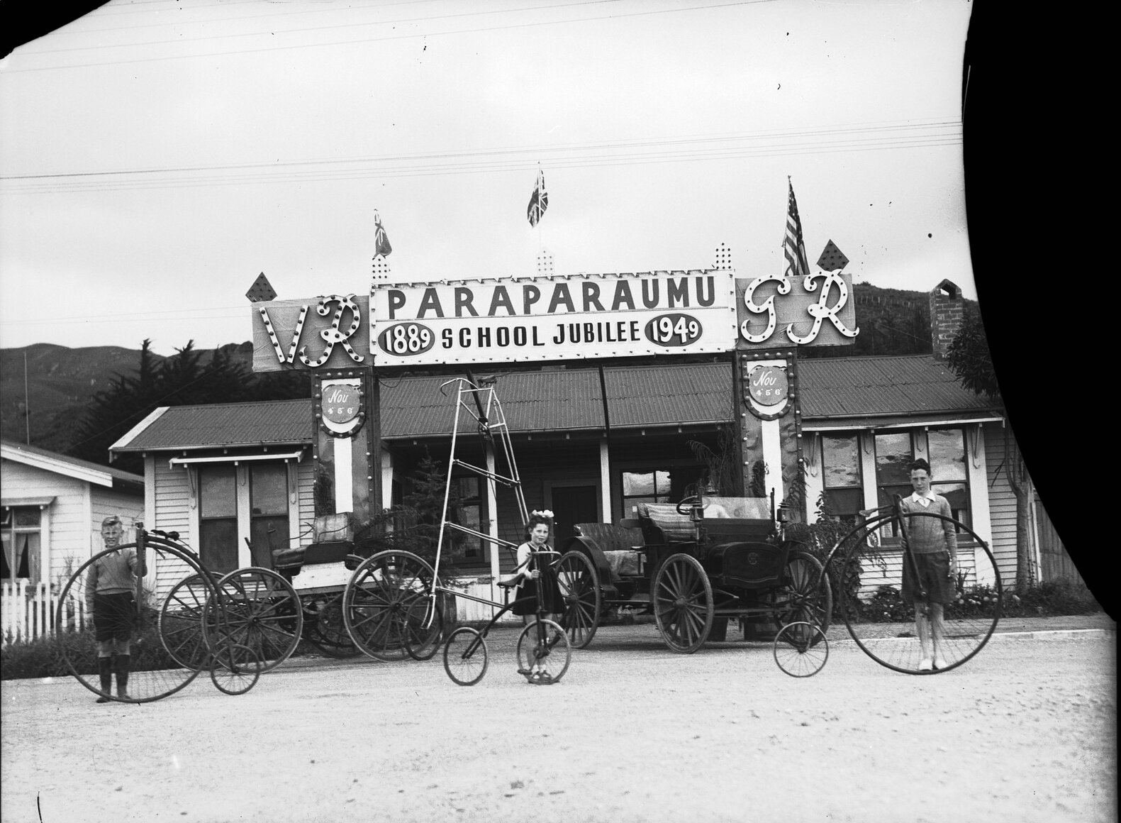 Children with old bicycles and motor vehicles
