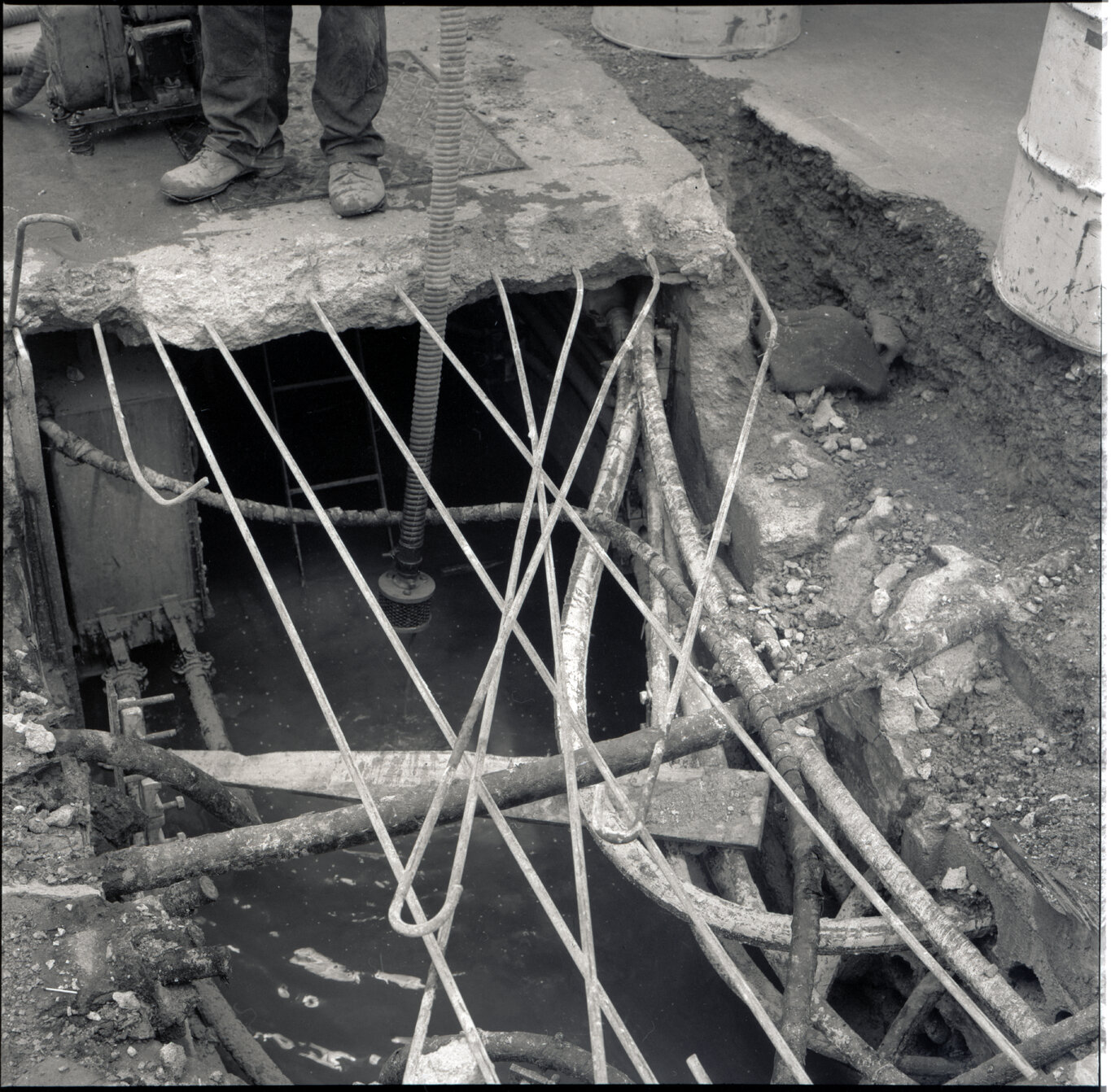 m. Various stages of asphaltic road surfacing by Council workmen, Lambton Quay end of Featherston Street. People passing by have stopped to watch work in progress. Trolly buses in background