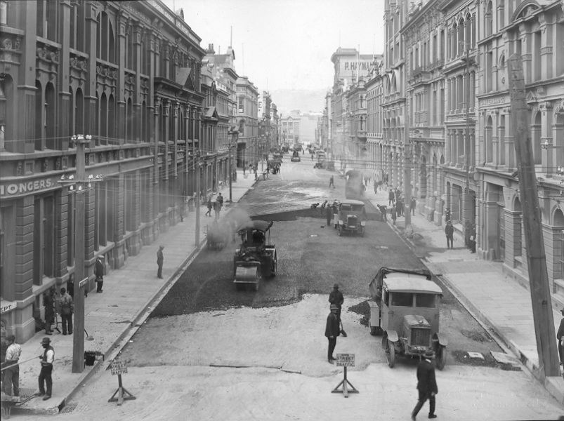 Elevated view of Victoria Street with asphaltic concrete paving in progress, number of workmen and equipment, Victoria Street, March 1924