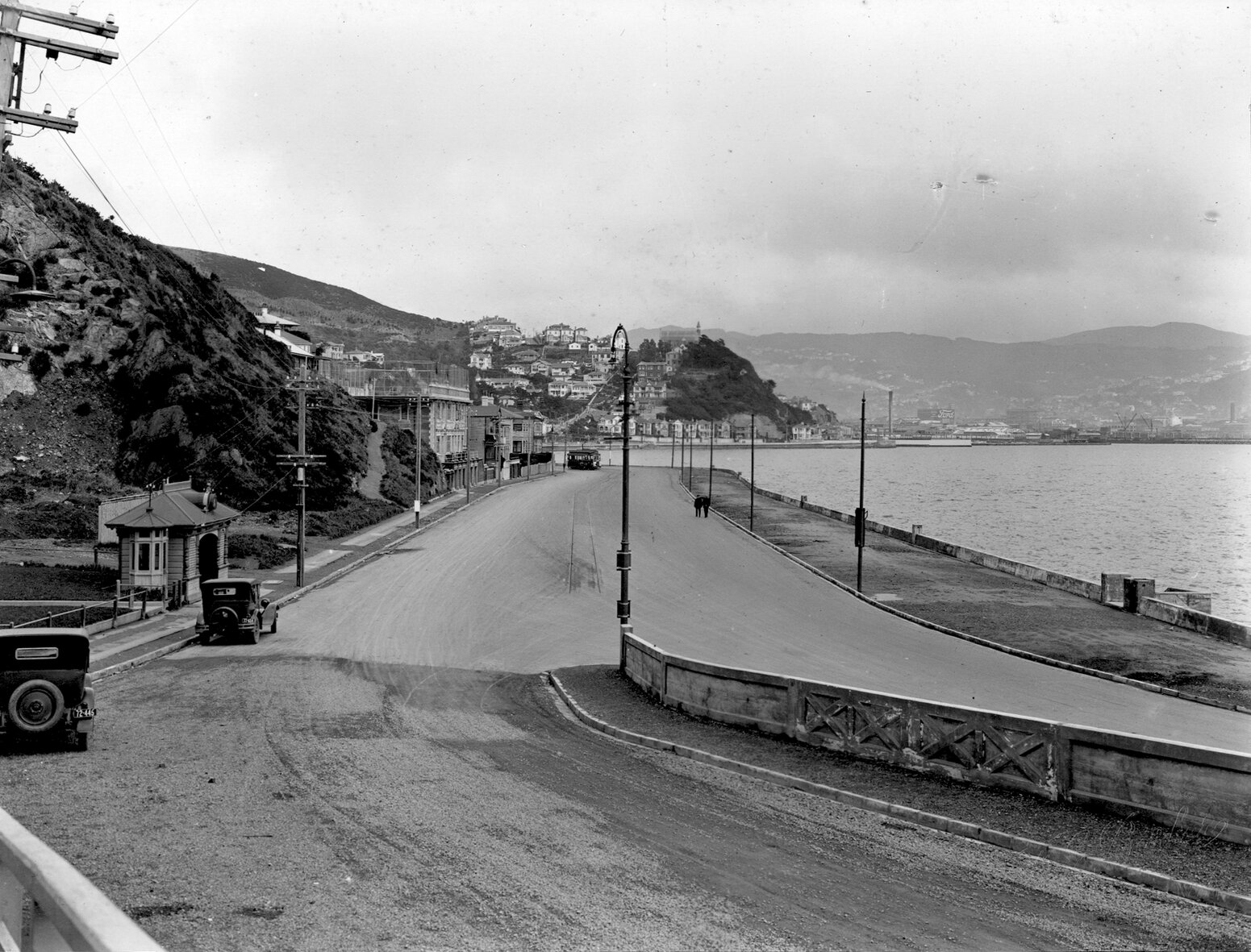 Carlton Gore Road intersection, parked motor vehicles, tram. View across harbour to Te Aro, Oriental Parade, December 1925