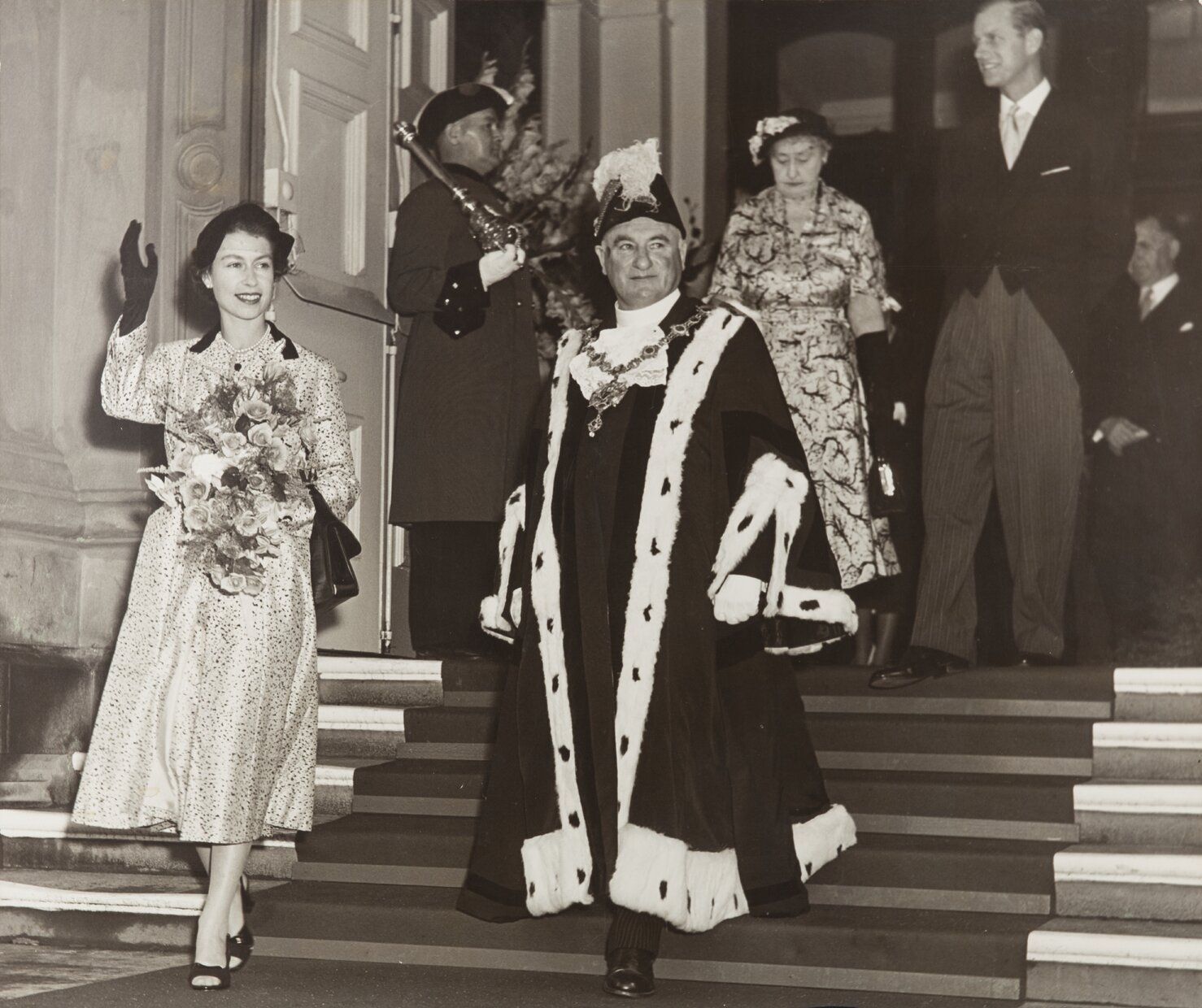 Queen Elizabeth II with Sir Robert Macalister, Mayor, descending main entrance stairs of Town Hall
