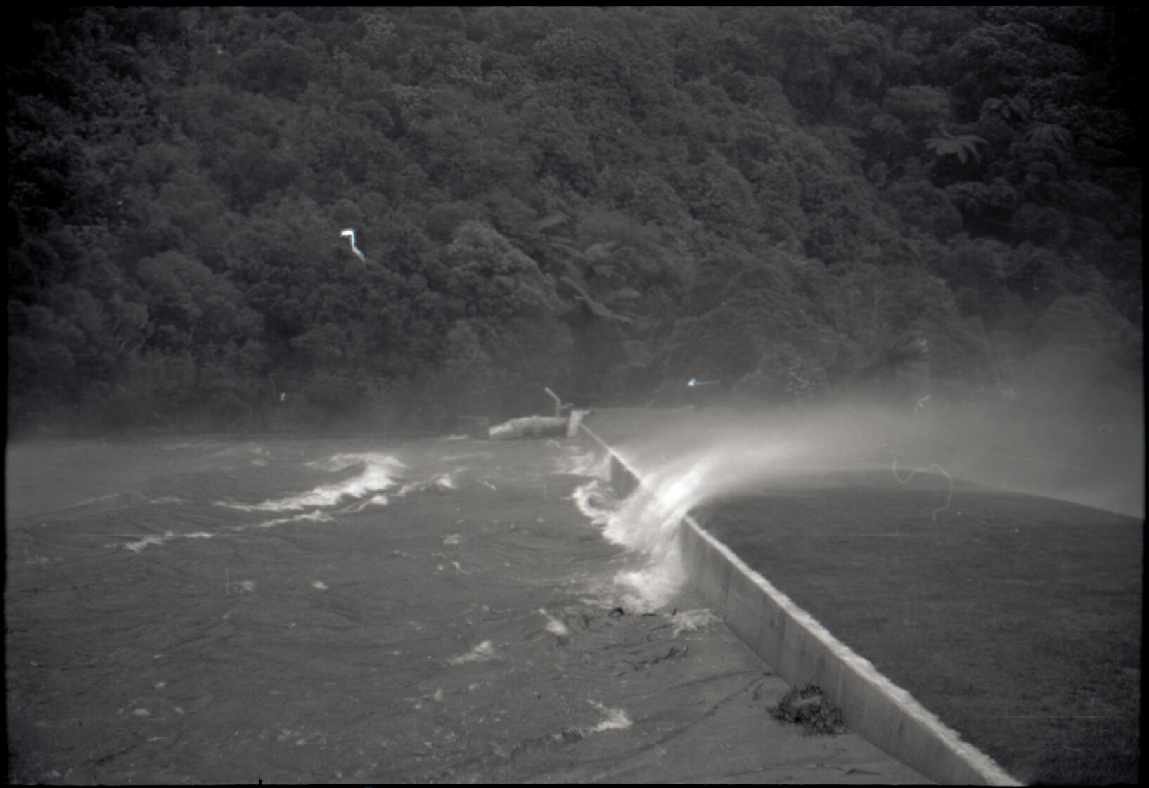 Photograph of water blowing over lower Karori dam during the Wahine storm