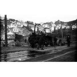Glenmore Street, workman operating the Cold Fix Spraying Outfit and Track Roller on newly laid tram rails