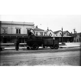 Kent Terrace, workmen hoisting drums of Cold Fix onto Cold Fix Spraying Trailer