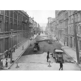 Elevated view of Victoria Street with asphaltic concrete paving in progress, number of workmen and equipment, Victoria Street, March 1924