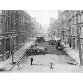Elevated view of Victoria Street with alsphatic concrete paving in progress, number of workmen and equipment, Victoria Street, March 1926