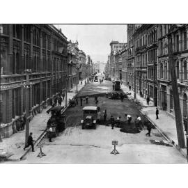 Elevated view of Victoria Street with alsphatic concrete paving in progress, number of workmen and equipment, Victoria Street, March 1926
